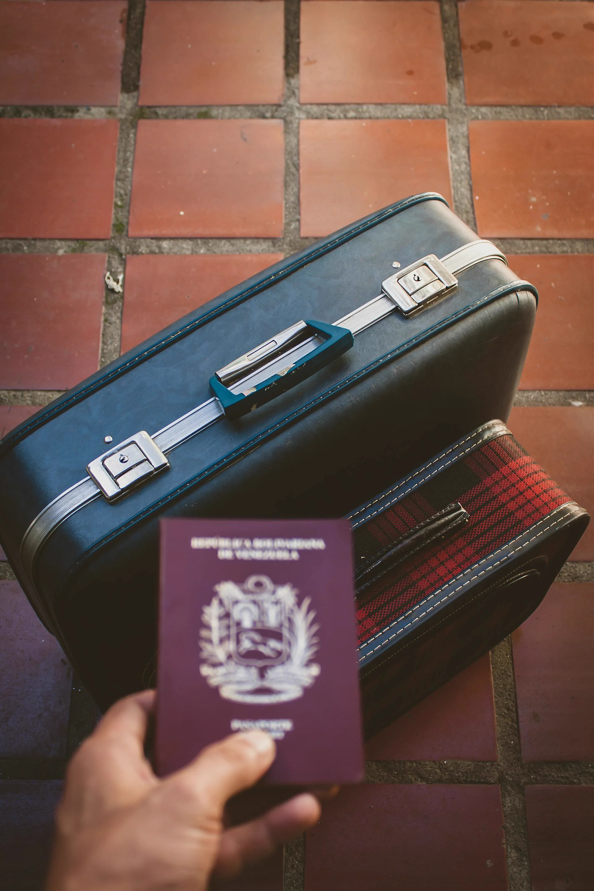 Passport in hand in front of a packed suitcase — the documents the AI extracts from