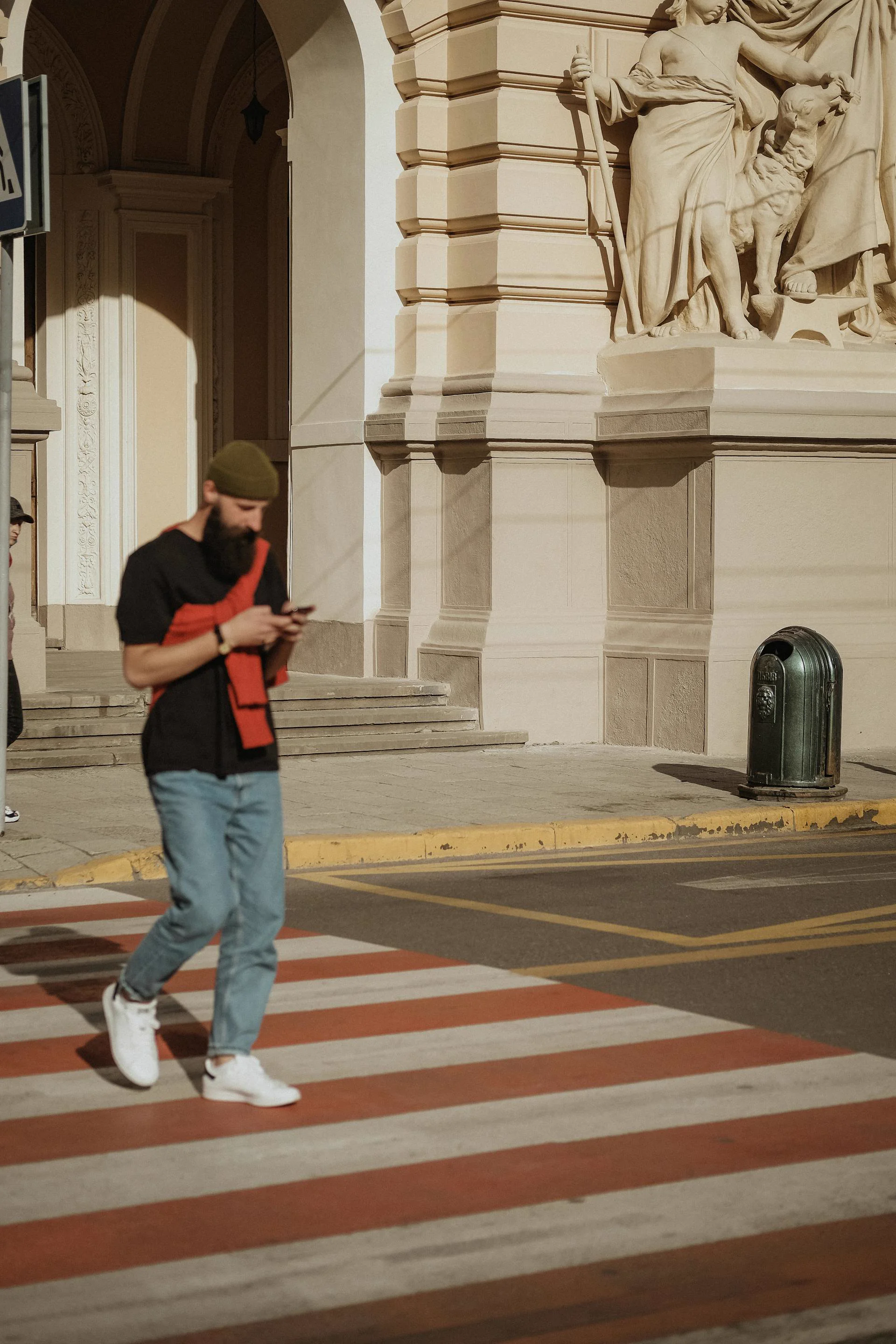 Pedestrian crossing a European city street while checking the Walking Guide on their phone